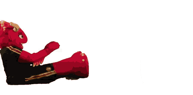 a stuffed animal in a red and black outfit is sitting on the floor