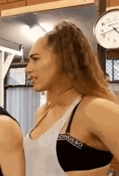 a woman is standing next to a man in a gym .