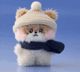 a stuffed animal wearing a hat and scarf has the letter a on its face
