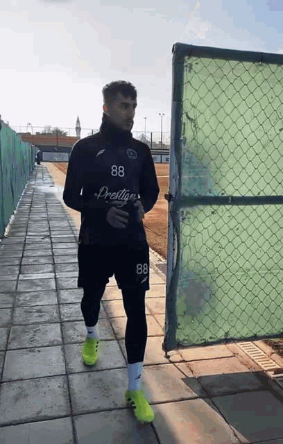a man with the number 88 on his shirt walks down a sidewalk