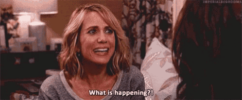 a woman is sitting on a couch talking to another woman and saying what is happening .