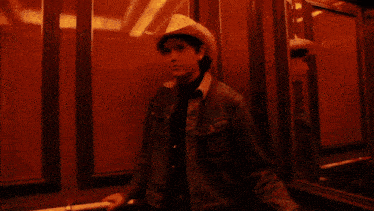 a man in a cowboy hat stands in front of a wall that says viii