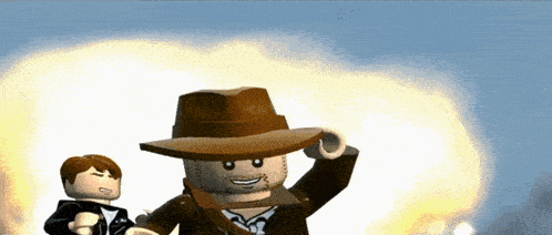a lego man wearing a cowboy hat is standing next to a man in a suit