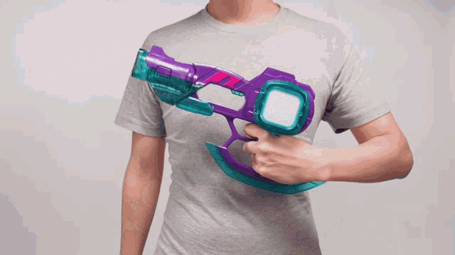 a man holding a purple and blue toy gun
