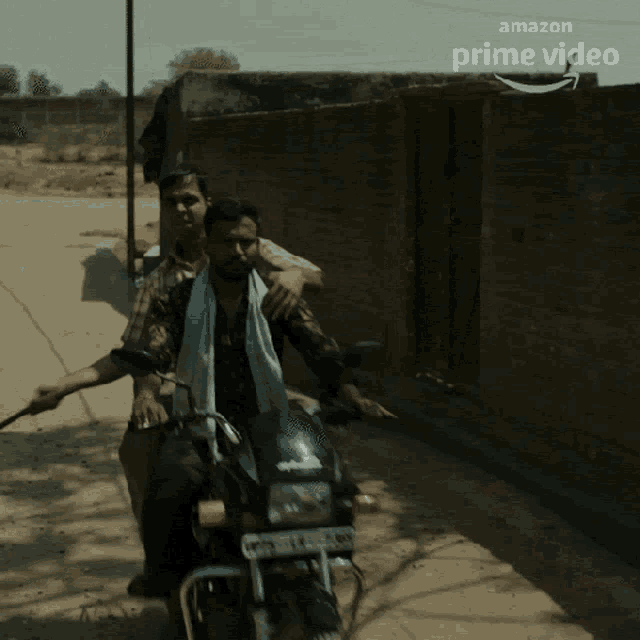 a man riding a motorcycle with a towel around his neck and a sign that says amazon prime video
