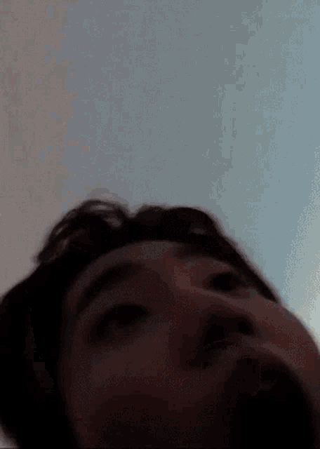 a close up of a person 's face with a blue sky in the background .