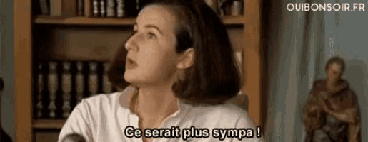 a woman is sitting in front of a bookshelf and saying ce serait plus sympa !