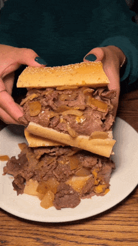 a person is holding a sandwich that is stacked on top of each other on a plate