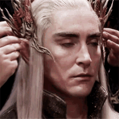 a man with long white hair and a crown on his head .