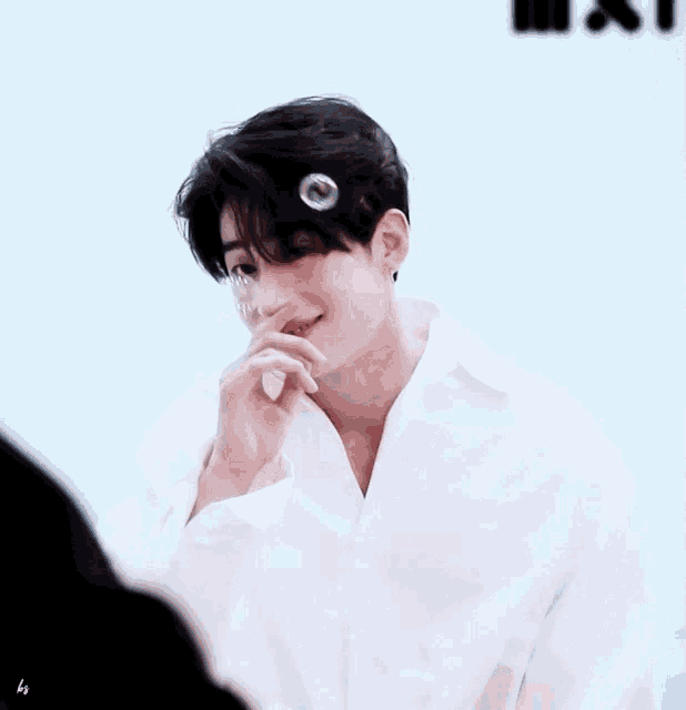 a young man in a white shirt is blowing soap bubbles and smiling