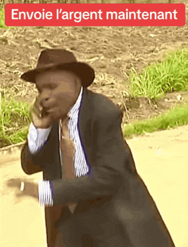 a man in a suit and hat is talking on a cell phone with the words envoie l' argent maintenant written above him