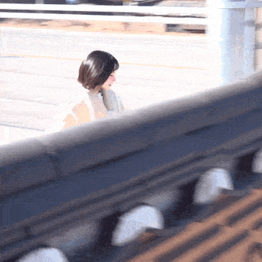 a woman in a white dress is walking down a sidewalk