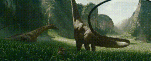 a group of dinosaurs are standing in a field .