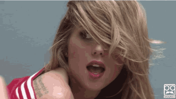 a close up of a woman 's face with a tattoo on her arm
