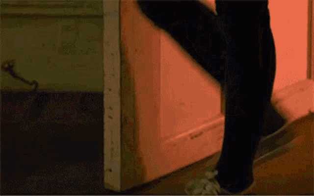 a person is standing in front of a door with a red light behind them
