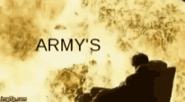 a man is sitting in front of a fire with the words army 's on the bottom