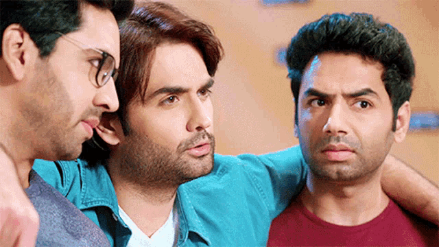 three men are standing next to each other and one of them has glasses on