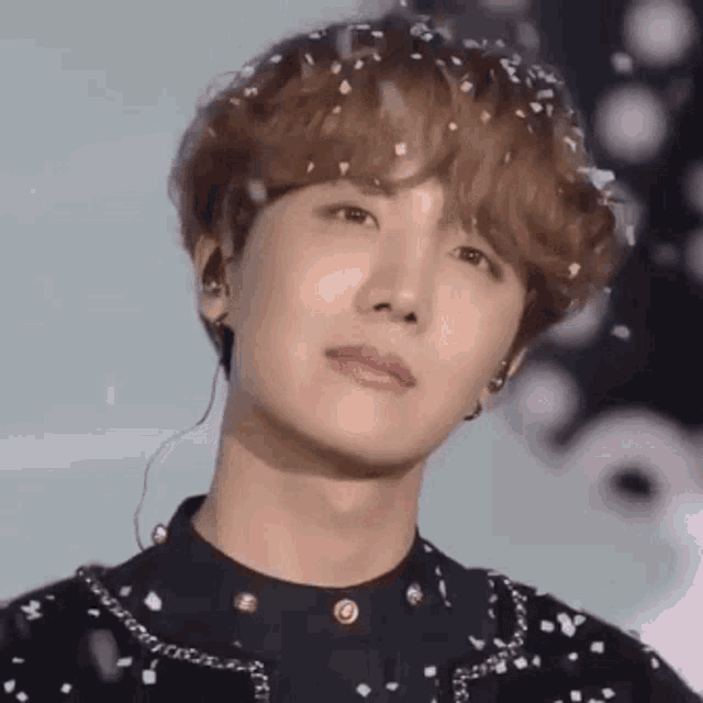 a close up of a man 's face with confetti falling from his hair .