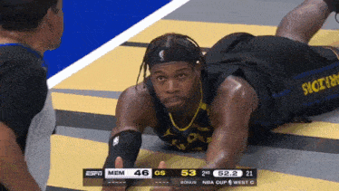 a basketball player laying on the floor with a scoreboard behind him that says espn mem 46 gs 52.2 bonus 21