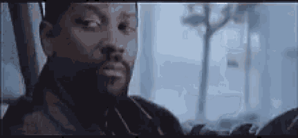 a man with a beard is sitting in front of a window in a car .