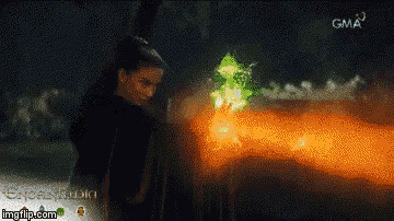 a woman is standing in front of a fire with gma written on the bottom right