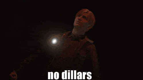 a man holding a flashlight in a dark room with the words no dollars above him