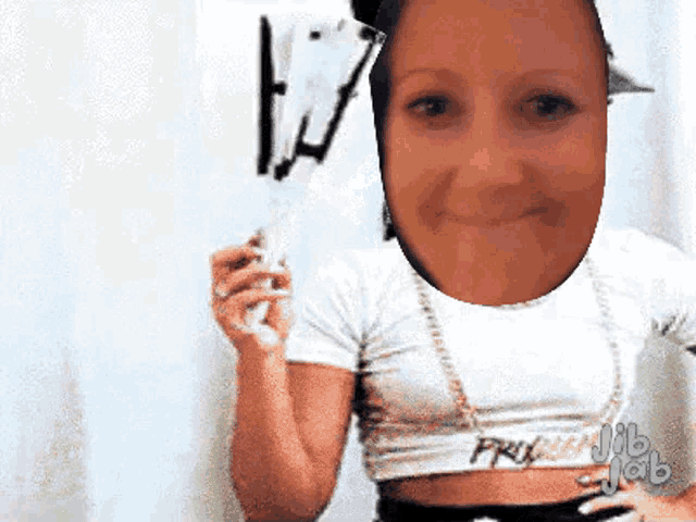a woman in a white crop top is holding a white wand .