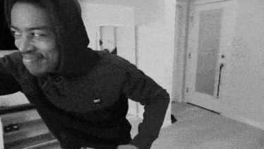 a black and white photo of a man wearing a hoodie that says dst on the chest