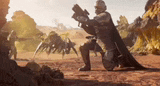 a man is kneeling down holding a gun in the desert .