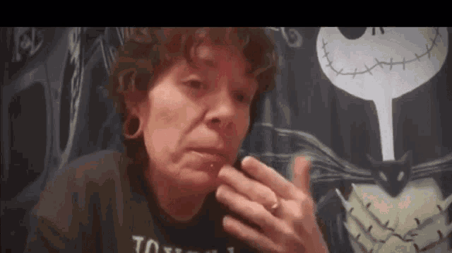 a woman with a ring on her finger is sitting in front of a nightmare before christmas curtain ..