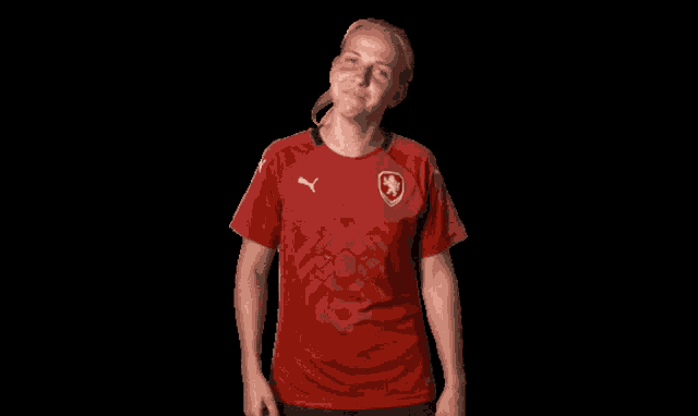 a woman is wearing a red shirt with a puma logo on it