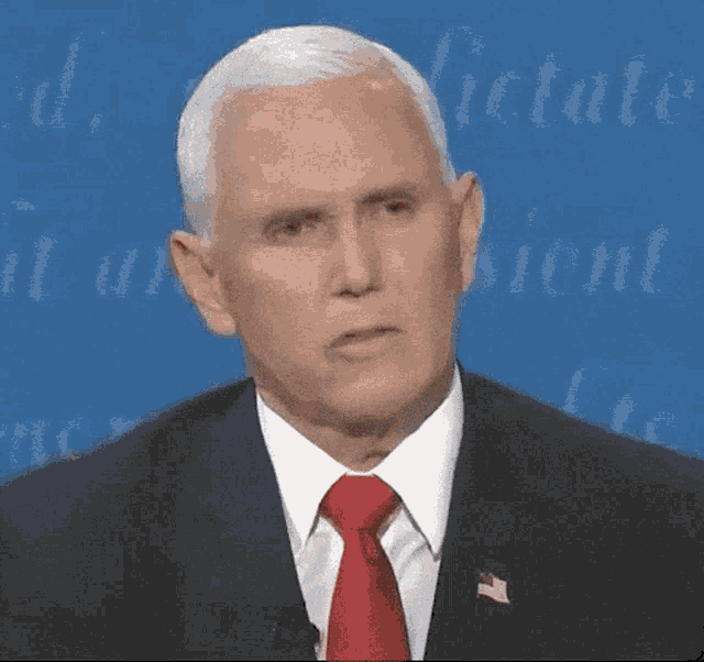 mike pence is wearing a suit and tie and making a face
