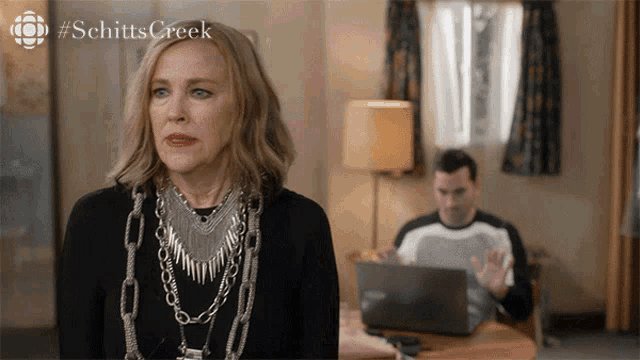 a screenshot from schitts creek shows a woman wearing a silver necklace