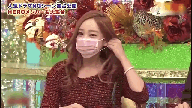 a woman wearing a face mask is sitting in front of flowers