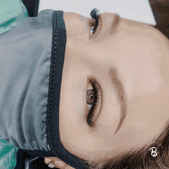 a woman wearing a mask with the letter b on her head
