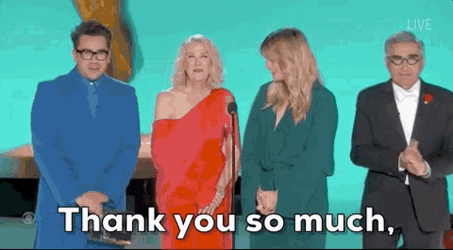 a group of people are standing next to each other on a stage and saying thank you so much .