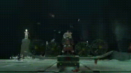 a blurred image of a fountain at night with a person standing in the background .