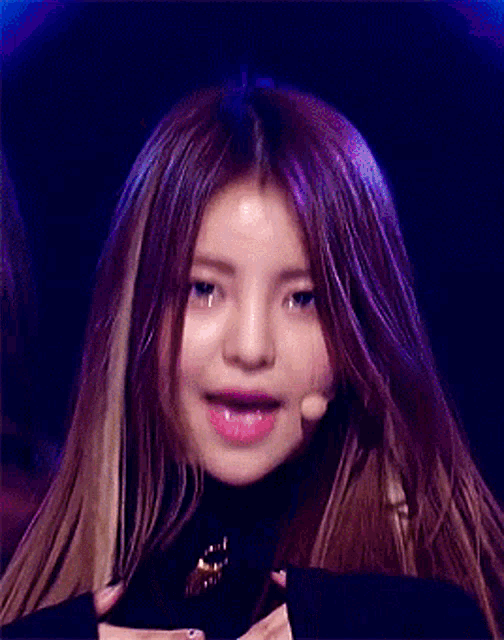 a woman with long hair is making a funny face with her mouth open .