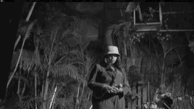 a black and white photo of a man in a suit playing an ukulele