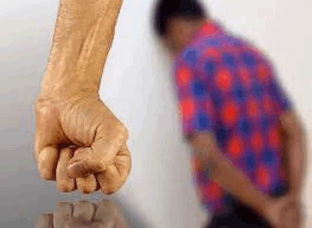 a man is standing in front of a fist that is being thrown at him .