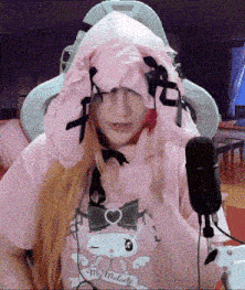 a woman wearing a pink hoodie and a shirt that says my melody