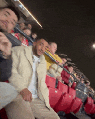 a group of people are sitting in the stands at a stadium