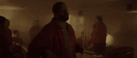 a group of men in red jackets are playing pool in a dark room