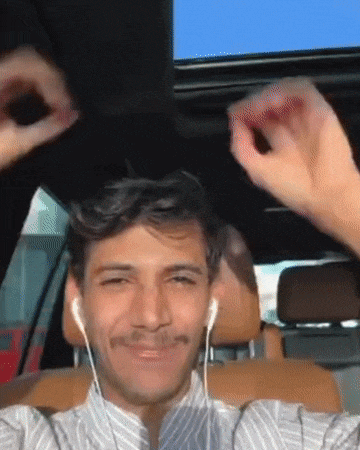 a man wearing ear buds is sitting in a car