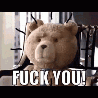 a teddy bear is sitting in a chair with spikes on its head and the words `` fuck you '' written on it .