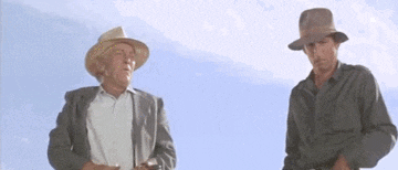 two men are standing next to each other wearing hats