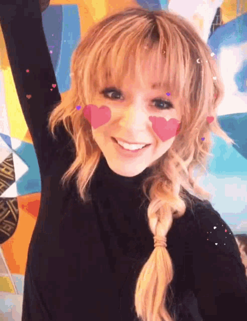 a woman with hearts painted on her face smiles