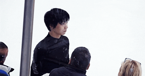 a man in a black wetsuit is standing next to another man in a black wetsuit .