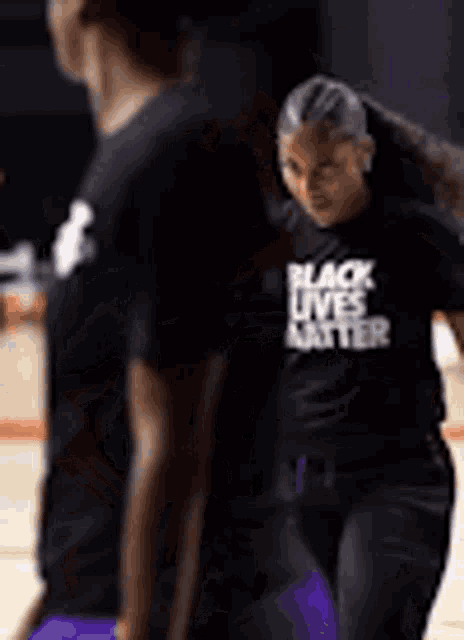 a woman is wearing a black t-shirt that says `` black lives matter '' .