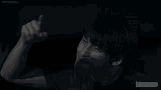 a man 's face is shown in a dark room with the caption kapwing on the bottom